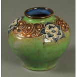 A Royal Doulton squat vase, relief moulded and tube lined to green ground.  Height 16.5 cm.