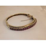A gold bangle set with graduated rubies CONDITION REPORTS Gold is unmarked, and carat / quality of