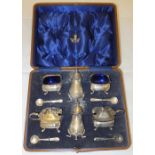 A cased silver condiment set to include
