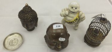 A Chinese brass 'four head' paperweight, a brass Buddha head, a 'birdcage' clock, an iron Michelin
