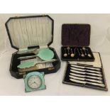 An Art Deco cased travelling set comprising travelling clock, hand mirror, clothes brush and