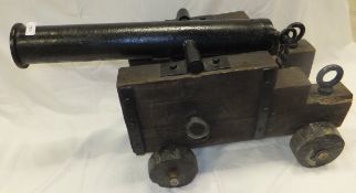 A cast iron canon on wooden carriage in