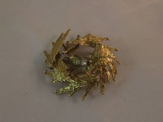 An 18 carat gold brooch of textured spiral form, mounted with a single diamond (maker's mark