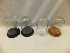 A collection of four glass domes, each o