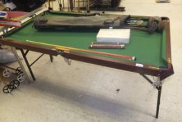 A modern child's folding miniature snooker table with balls, cues and scoreboard, and a bag of