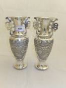 A pair of 20th Century silver Chinese twin-handled vases with stork and floral decoration, bears