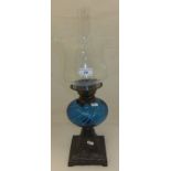 A Victorian oil lamp with a blue glass w