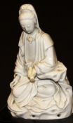 A 17th Century Chinese blanc-de-chine figure of Guan Yin in lotus position, holding a scroll in