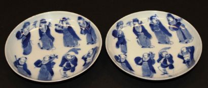 A pair of Chinese Guangxu blue and white saucers decorated with eight Immortals raised on a circular