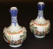 A pair of Chinese gourd shaped vases with polychrome decoration of warriors in a landscape flanked