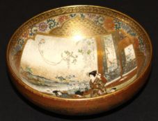 A Meiji period Japanese Satsuma ware bowl decorated with figures in an interior, raised on a