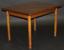 A mid 20th Century oak extending dining table by Gordon Russell, the cross banded top over a moulded