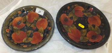 A Moorcroft pottery shallow dish decorated with pomegranate pattern on a mottled blue ground, a