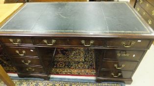 A Victorian mahogany nine drawer pedestal desk with black leather tooled top and brass handles on
