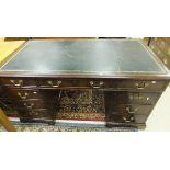 A Victorian mahogany nine drawer pedestal desk with black leather tooled top and brass handles on