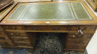 A yew wood nine drawer pedestal desk wit
