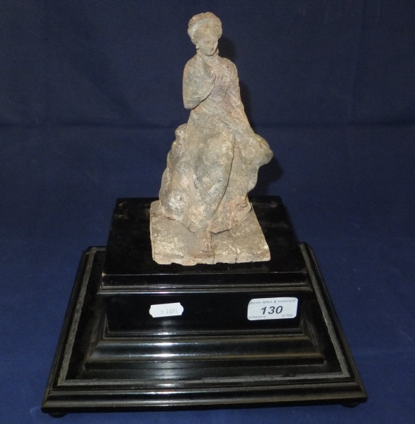 An Etruscan / Roman terracotta figure of a seated lady in Classical robes on a square plinth base,