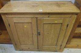 A Victorian pine cupboard, the plain top above two panelled doors, opening to reveal three shelves