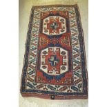 A Turkish rug, the two central medallions in terracotta, cream and blue on a terracotta ground