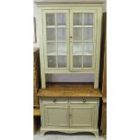 A modern painted pine kitchen cabinet with two glazed and barred doors over a recess and two drawers