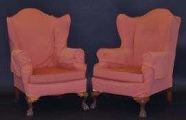 A pair of early 20th Century upholstered wing back scroll armchairs on shell carved cabriole legs to