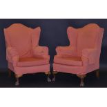 A pair of early 20th Century upholstered wing back scroll armchairs on shell carved cabriole legs to