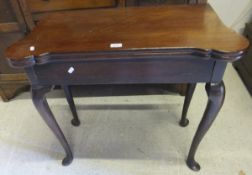 An 18th Century mahogany fold-over tea table, the shaped top above a single frieze drawer on