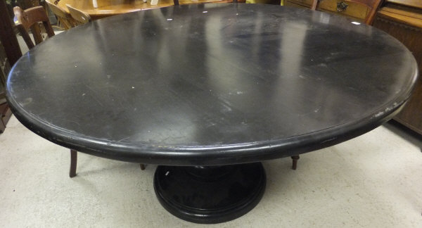 An ebonised circular breakfast table on