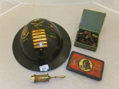 A World War I tin hat with painted decoration inscribed "Artist's Rifles 1915-16 Quo Fata Vocant