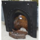 A cast iron fireplace with cast iron gra