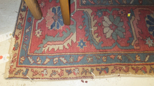 A Caucasian carpet, the central blue, red, cream and mustard medallion on a plain red ground