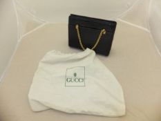 A vintage Gucci black crocodile skin handbag with gilt chain handles and a cotton Gucci protective
