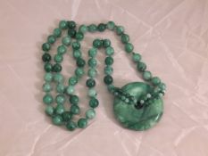A jade beaded necklace with ring pendant