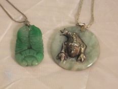 A jade pendant carved as two fish on a s