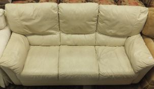 A cream leather three seater sofa