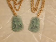 Two carved jade pendants, each depicting