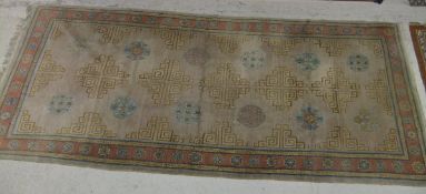 A Chinese carpet, the centre taupe ground decorated with geometric patterns in cream and pale