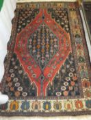 A Caucasian rug, the central medallion with rows of floral motifs on a dark blue ground within a red