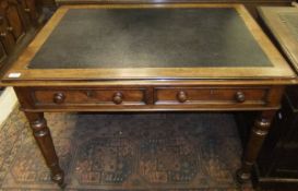 A Victorian mahogany writing table, the top with inset writing surface within a moulded edge over
