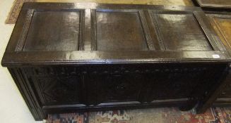 A late 17th Century oak coffer, the plain three panelled top with moulded stiles over lunette carved