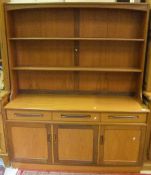 A teak G Plan dresser with three open sh