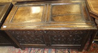 A 17th Century oak coffer, the plain two panel top with moulded stiles and edge over a foliate