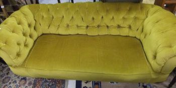 A Victorian Chesterfield sofa with mahogany turned front legs, upholstered in mustard yellow