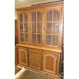 A pine dresser of three glazed doors enc