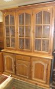 A pine dresser of three glazed doors enc
