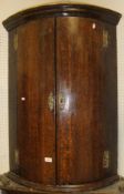 A circa 1800 oak bow fronted hanging cor