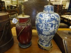 A Chinese sang de boeuf barrel bodied vase converted to a table lamp, on hardwood stand, together