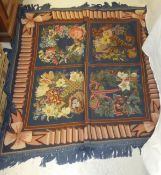 A woolwork stitched rug / throw, each of the four square central panels decorated with flowers on