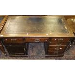 A mahogany pedestal desk with black leat