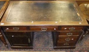 A mahogany pedestal desk with black leat